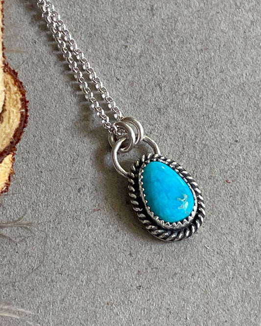 handcrafted petite blue ridge turquoise necklace set in serrated bezel with delicate rope border hung from double jump rings on delicate rolo chain