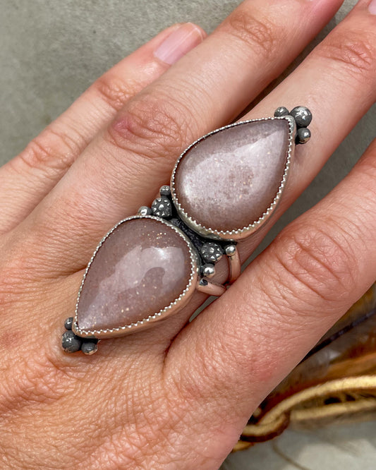 handcrafted sterling silver ring with chunk peach moonstone pear cabochons set end to end with hand forged accent beads at the points and in between stones set in serrated bezels on split shank band
