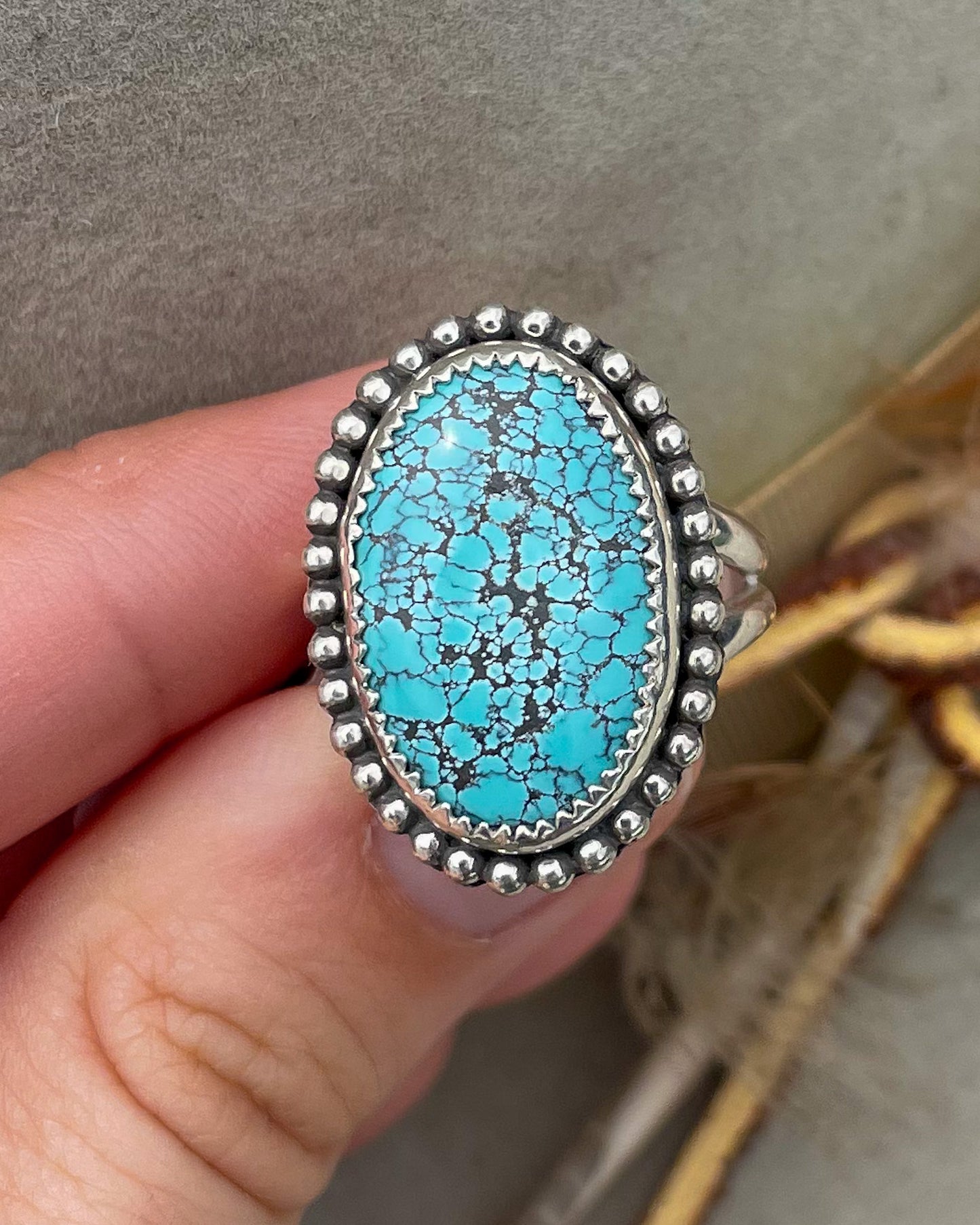 handcrafted blue moon turquoise oval ring in serrated bezel with beaded border on split shank band