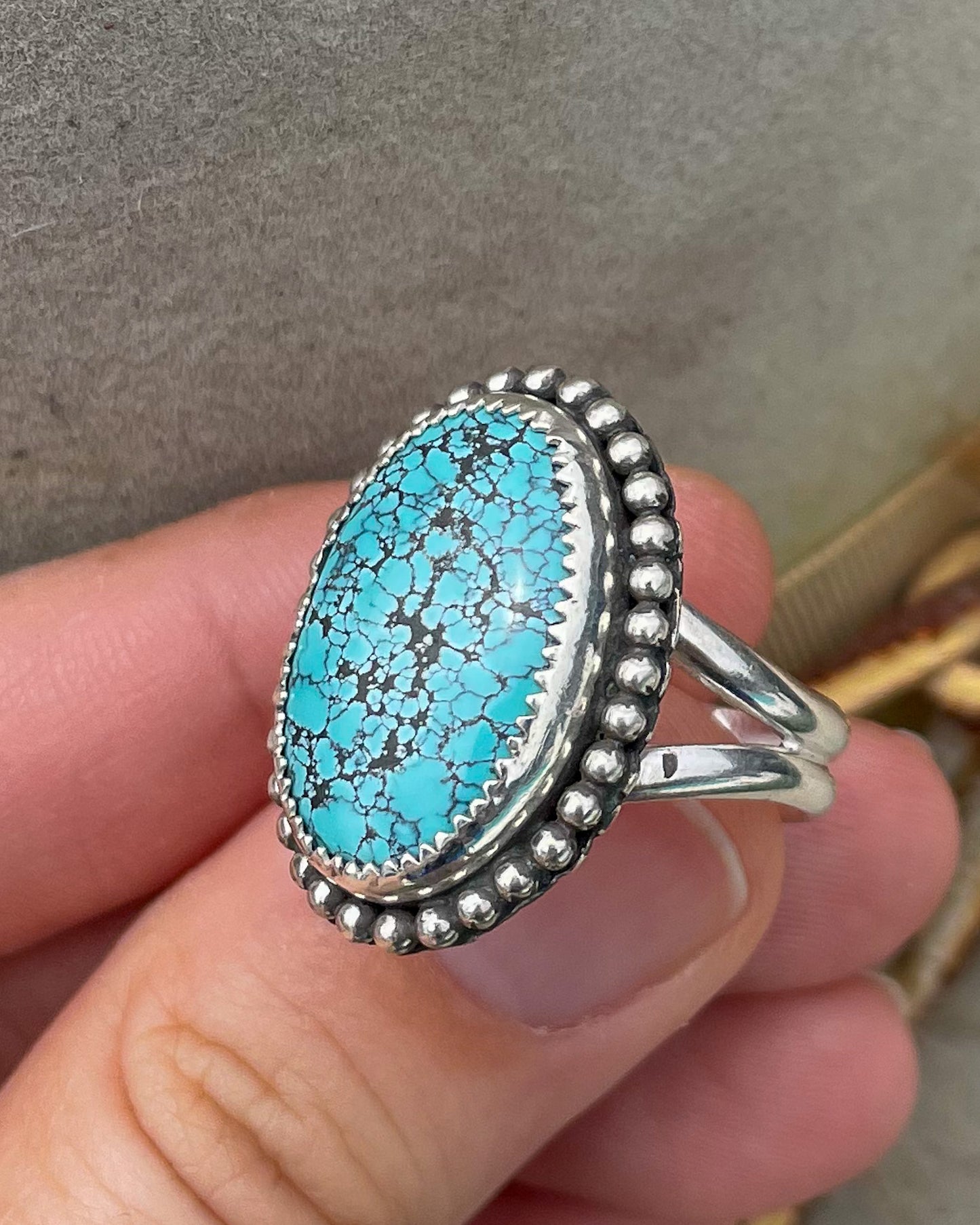 handcrafted blue moon turquoise oval ring in serrated bezel with beaded border on split shank band