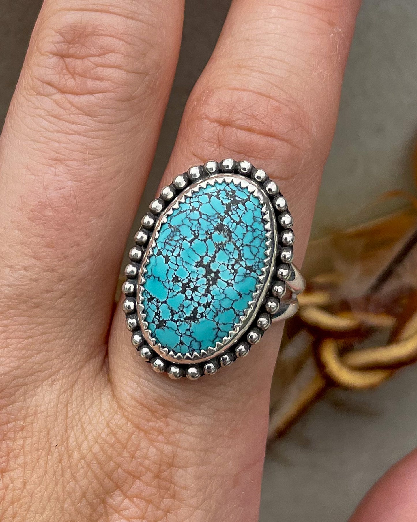handcrafted blue moon turquoise oval ring in serrated bezel with beaded border on split shank band