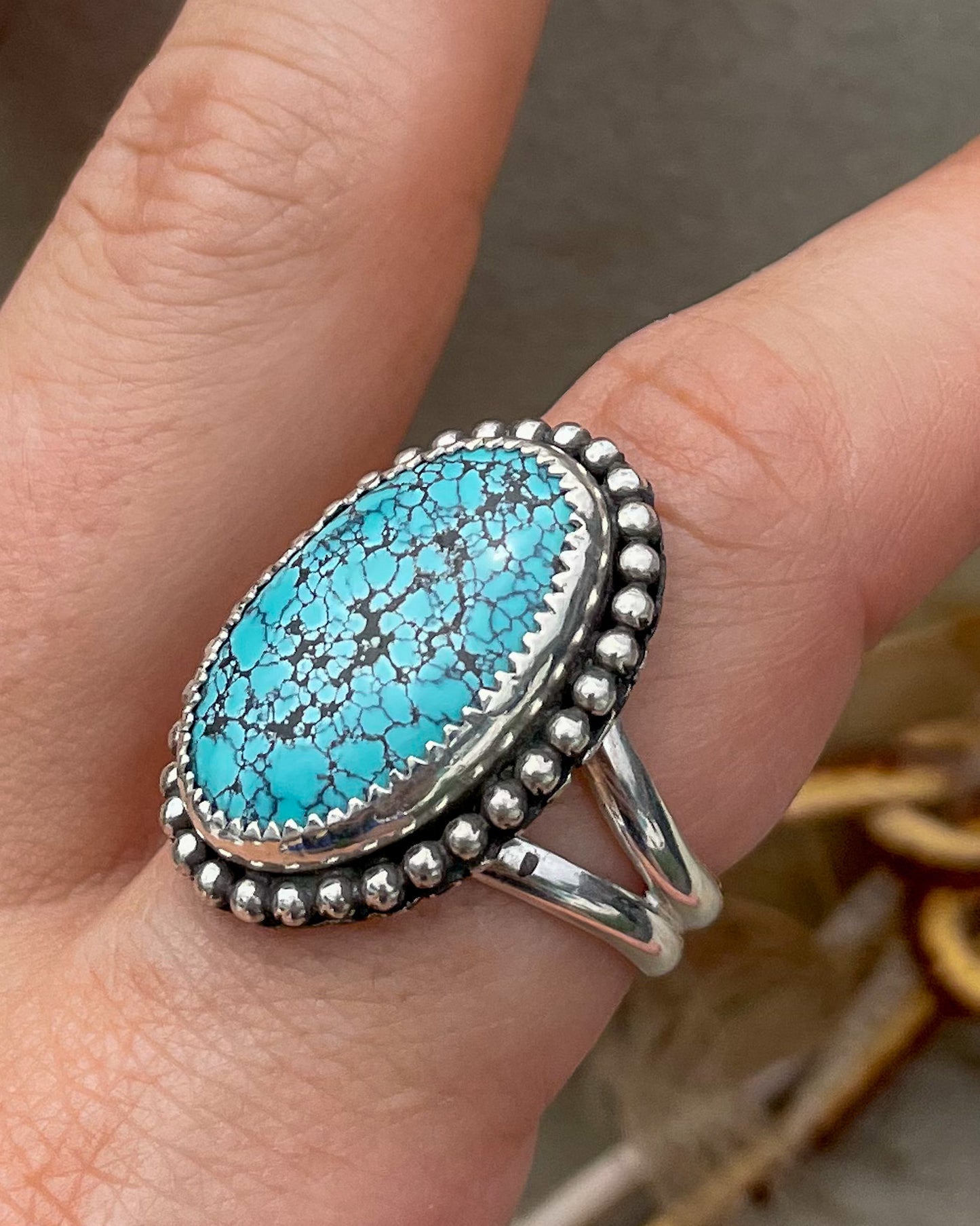 handcrafted blue moon turquoise oval ring in serrated bezel with beaded border on split shank band