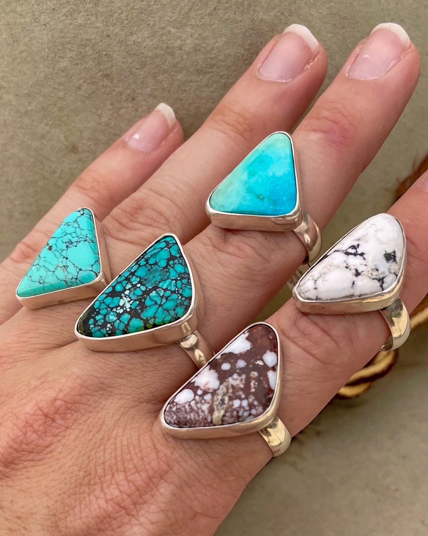 five turquoise triangular stone rings in smooth bezels on chunky silver bands