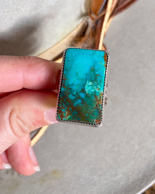 hand holding blue and green ombre pilot mountain turquoise rectangular ring