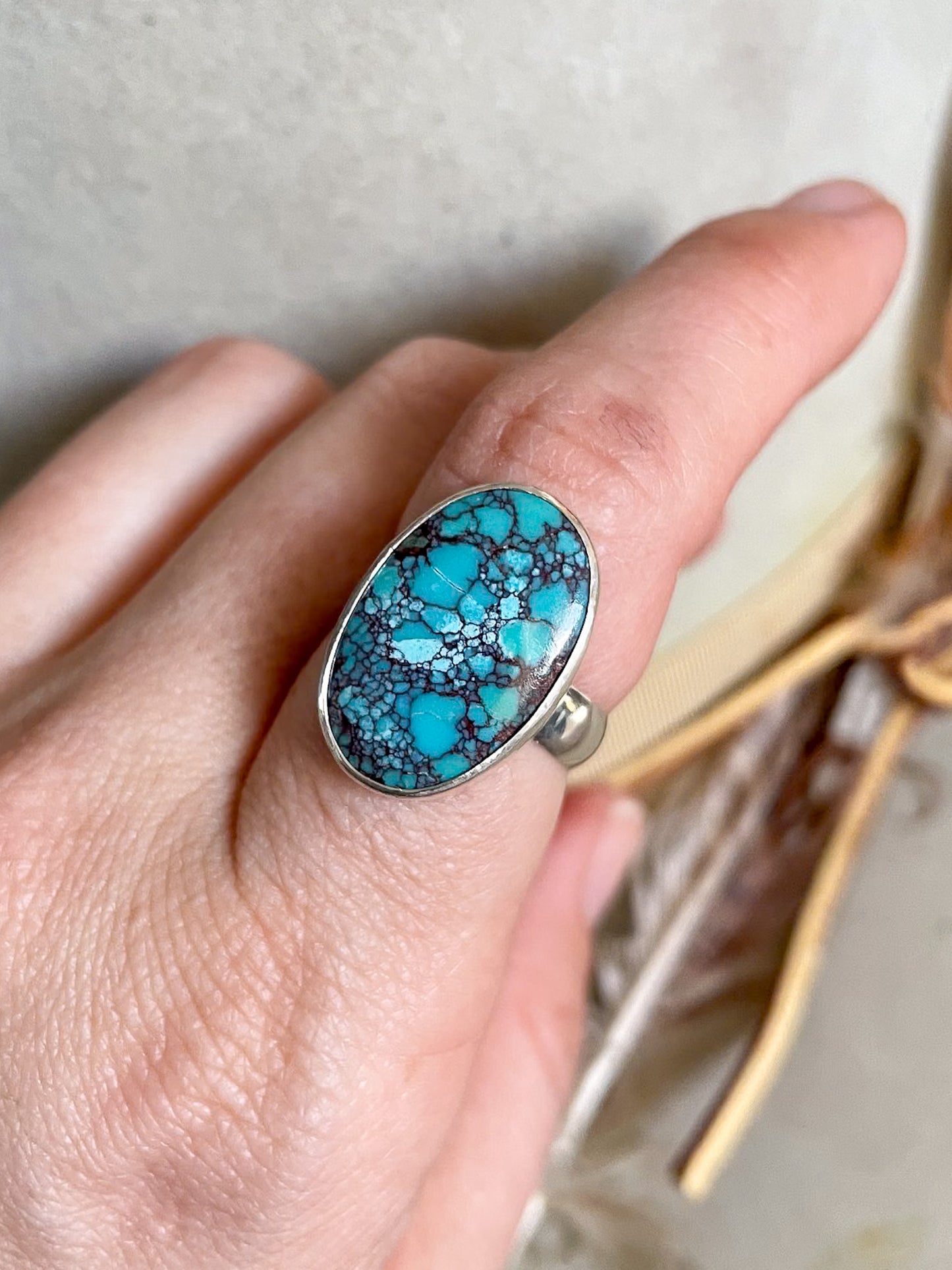 natural egyptian turquoise oval ring set in smooth bezel worn in hand