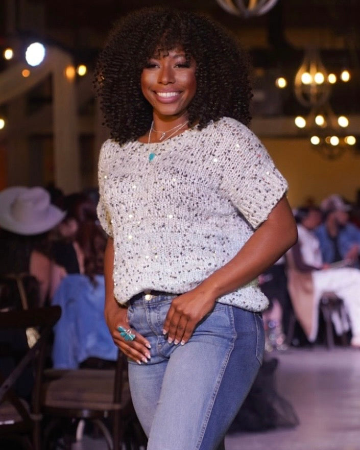 woman wearing peacock blue turquoise ring and necklace with sequin top on fashion show runway