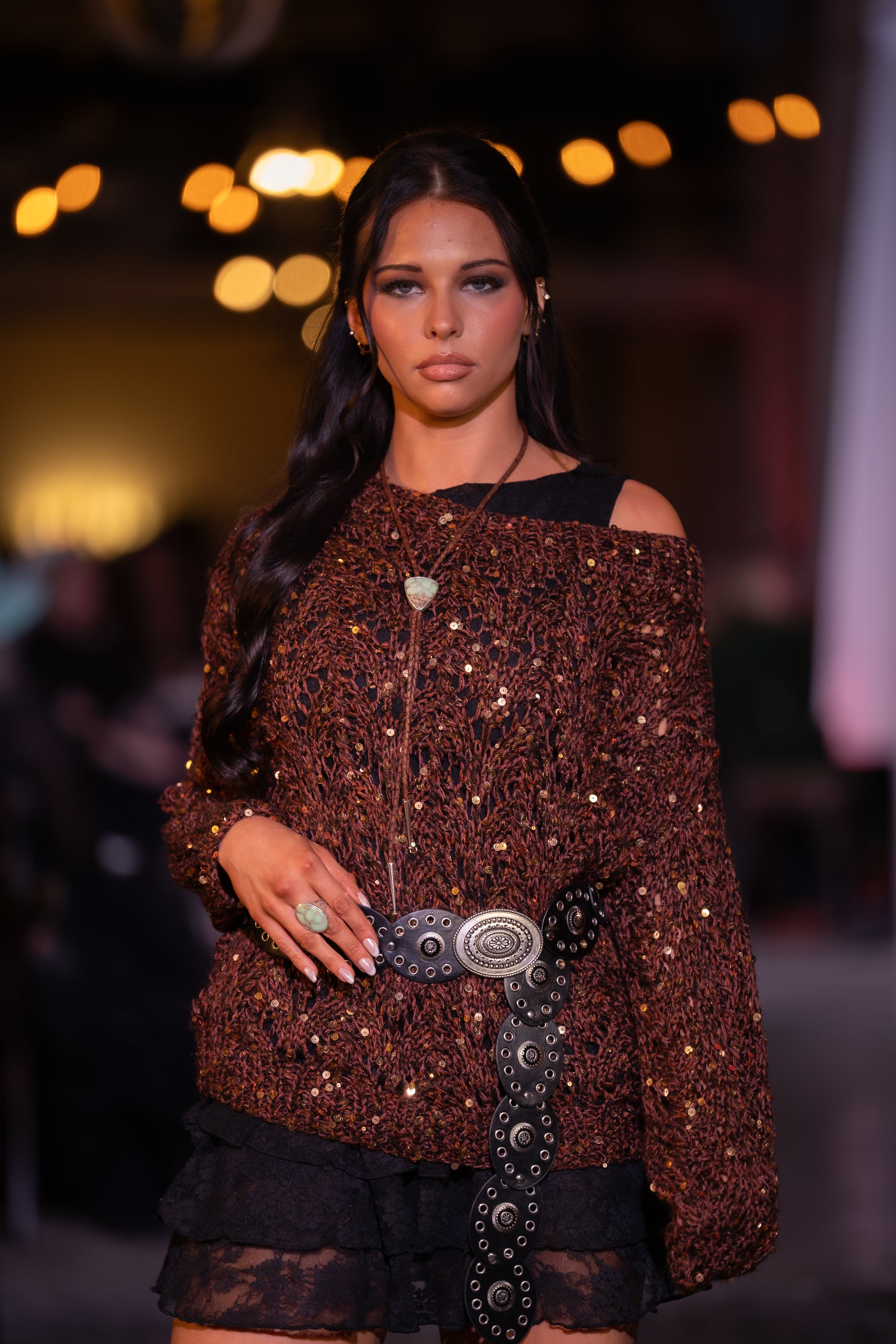 model wearing brown sweater with mint green turquoise bolo and ring on runway