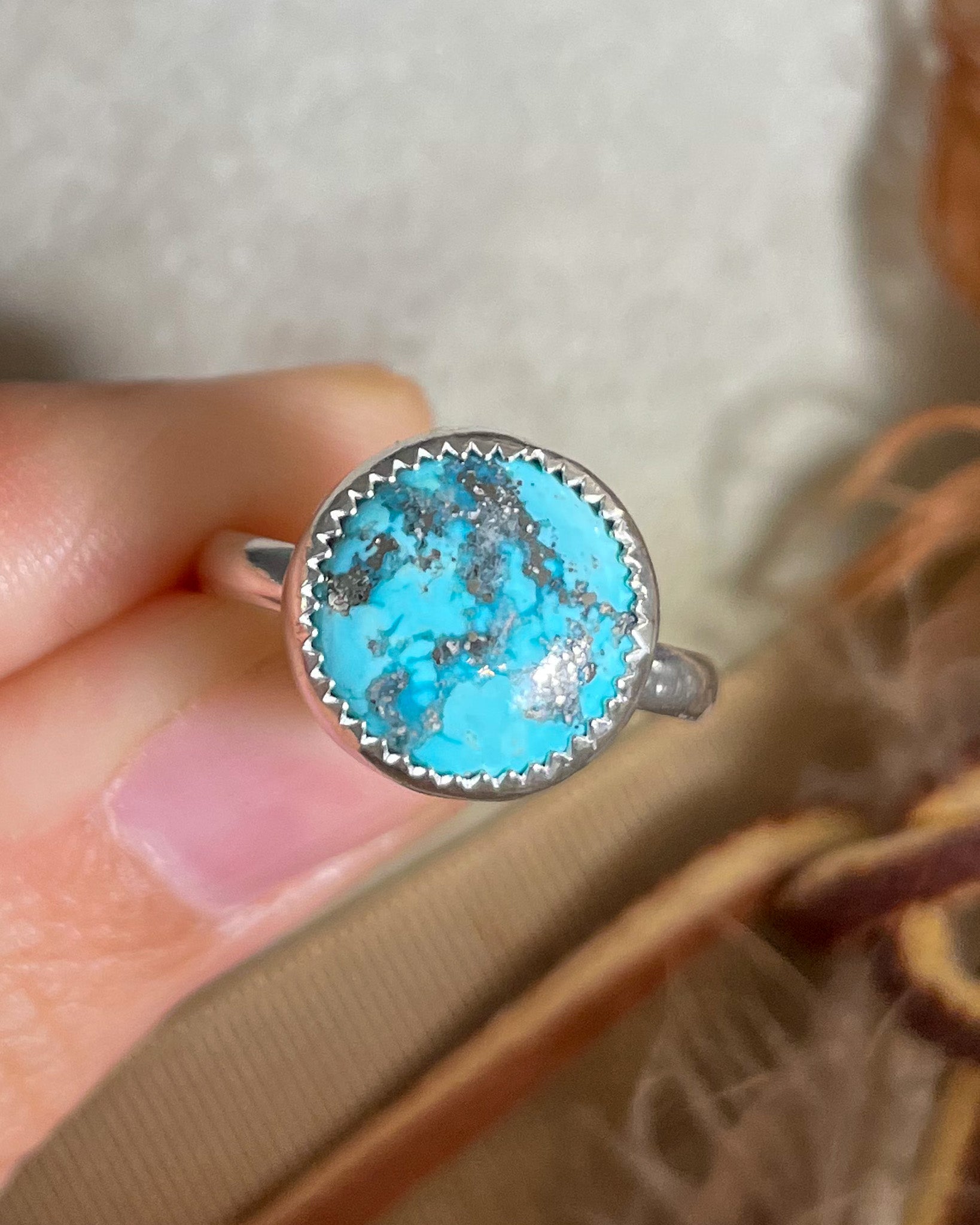 round white water turquoise ring handcrafted in serrated bezel on a half round band