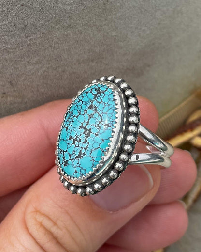 handcrafted blue moon turquoise oval ring in serrated bezel with beaded border on split shank band