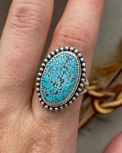 handcrafted blue moon turquoise oval ring in serrated bezel with beaded border on split shank band