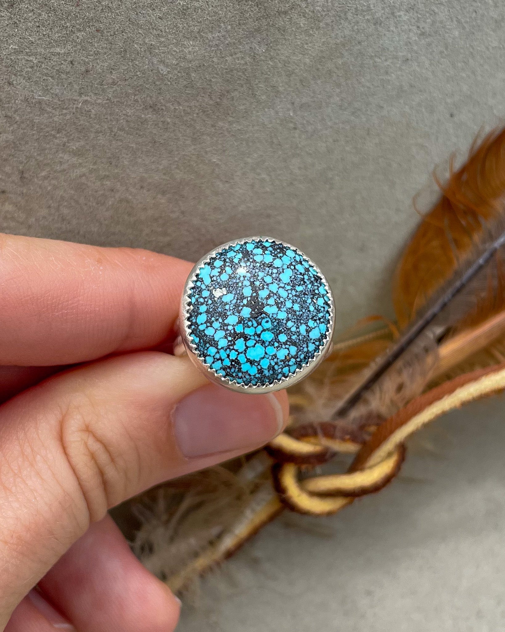 medium sized handmade natural spiderweb kingman turquoise round ring with natural pyrite fleck in a serrated bezel on a double half round band