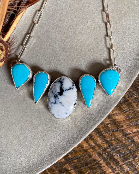 necklace with white buffalo center stone and two matching sleeping beauty stones mirrored on each side on paperclip chain