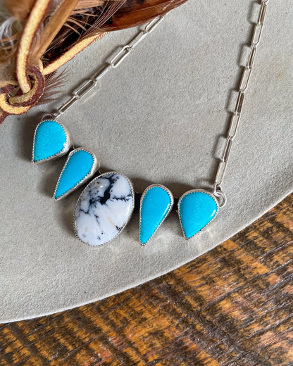 necklace with white buffalo center stone and two matching sleeping beauty stones mirrored on each side on paperclip chain