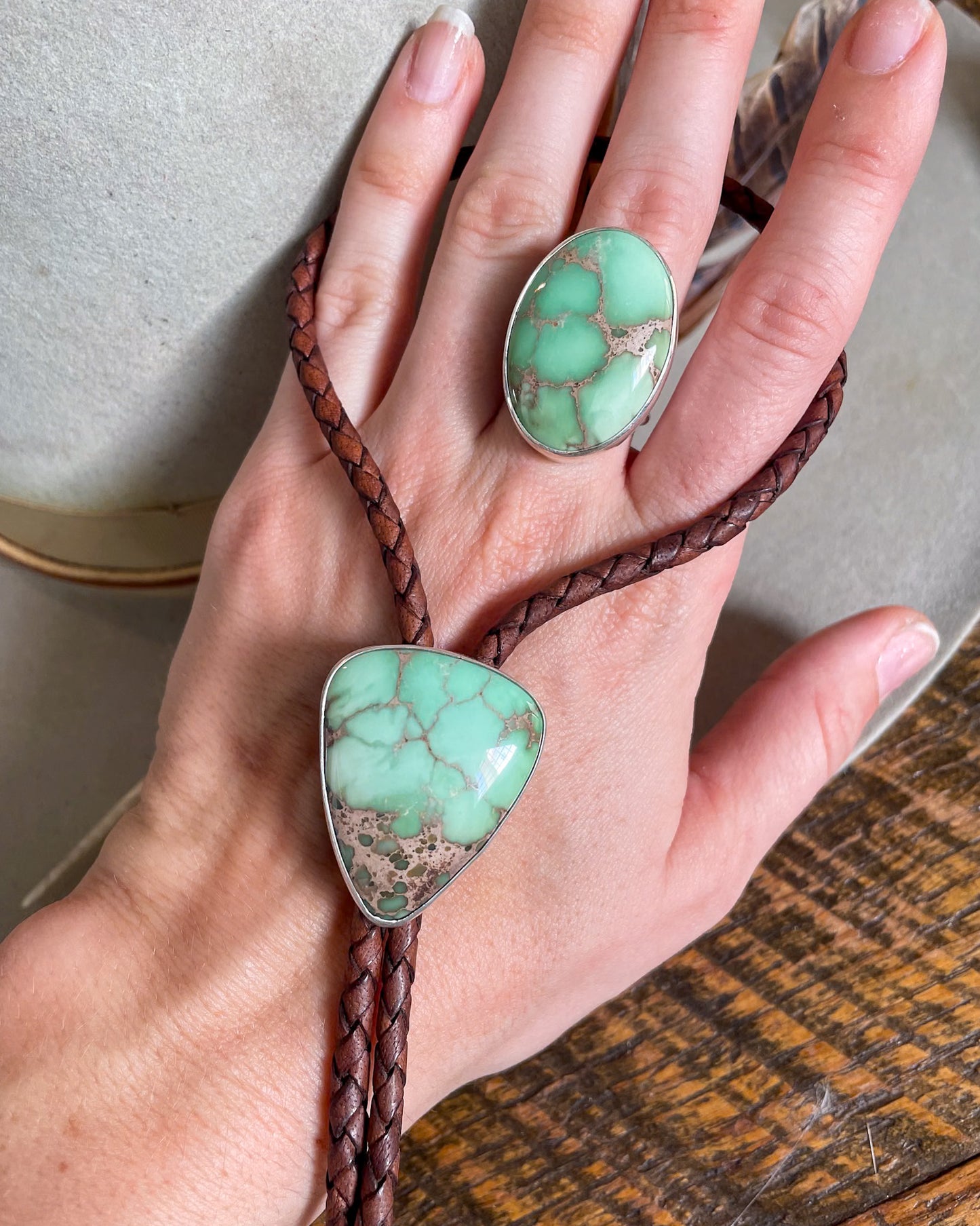 Large oval mint green turquoise ring and matching bolo on brown leather cord on hand