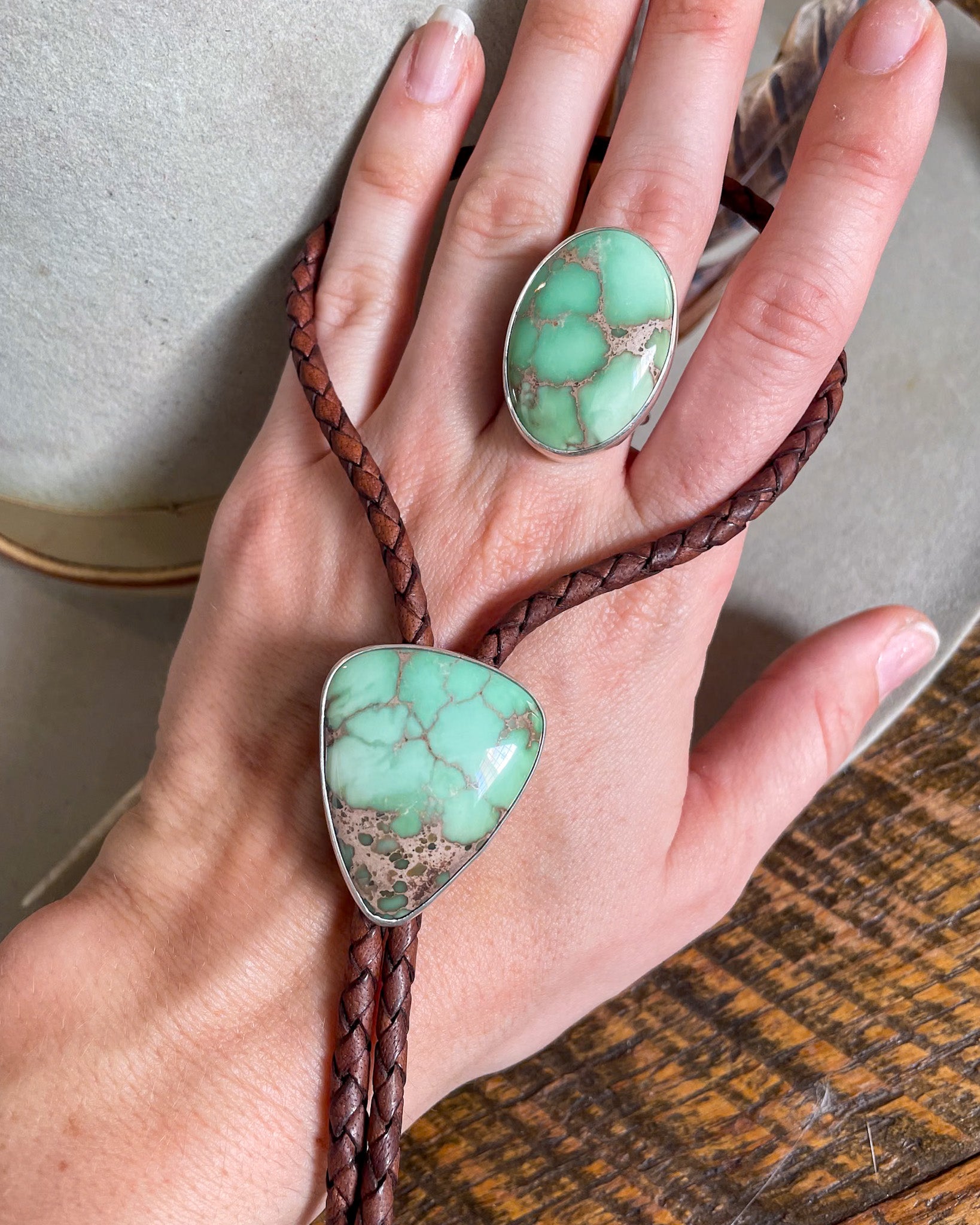 Large oval mint green turquoise ring and matching bolo on brown leather cord on hand