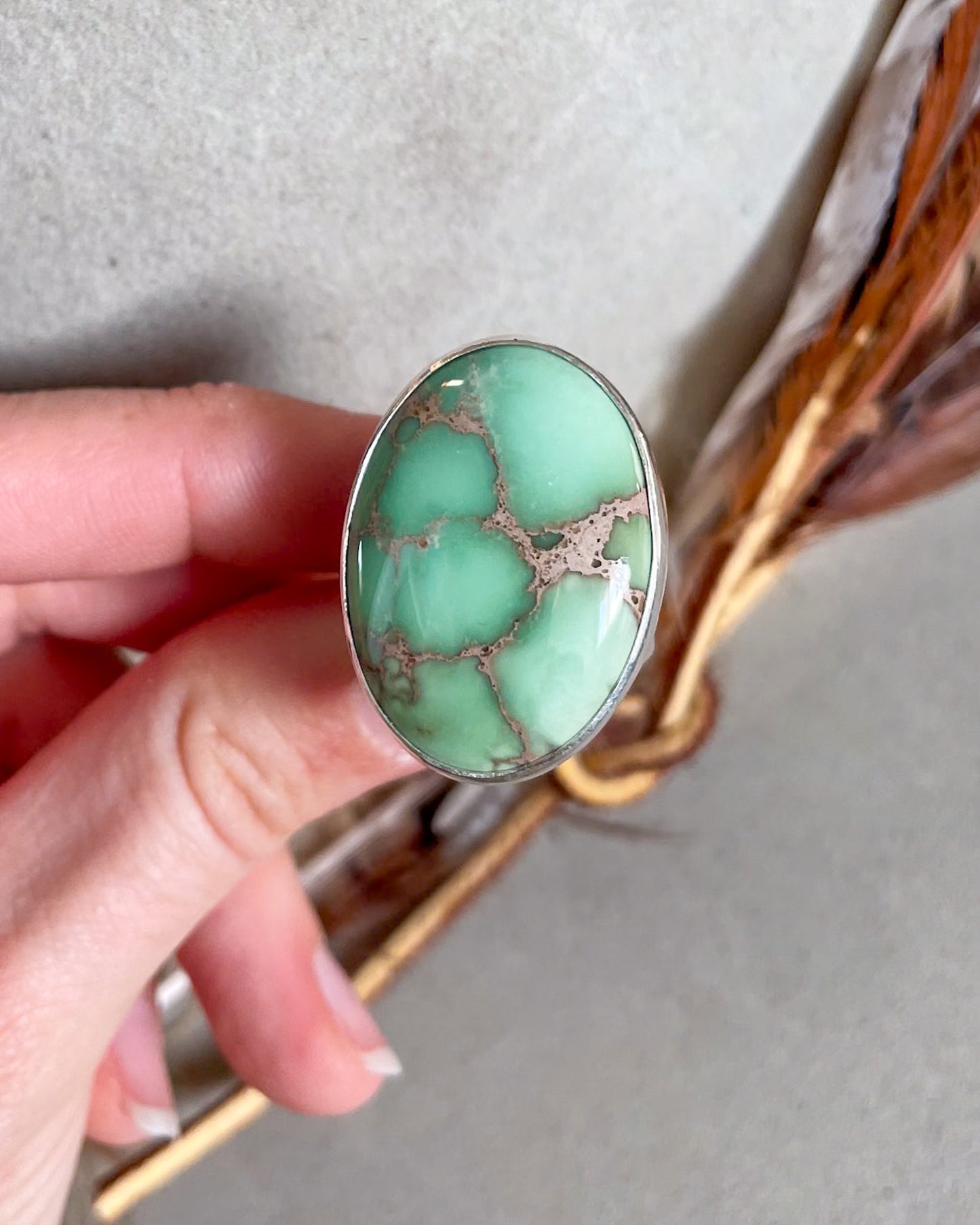 Hand holding Large oval mint green turquoise ring
