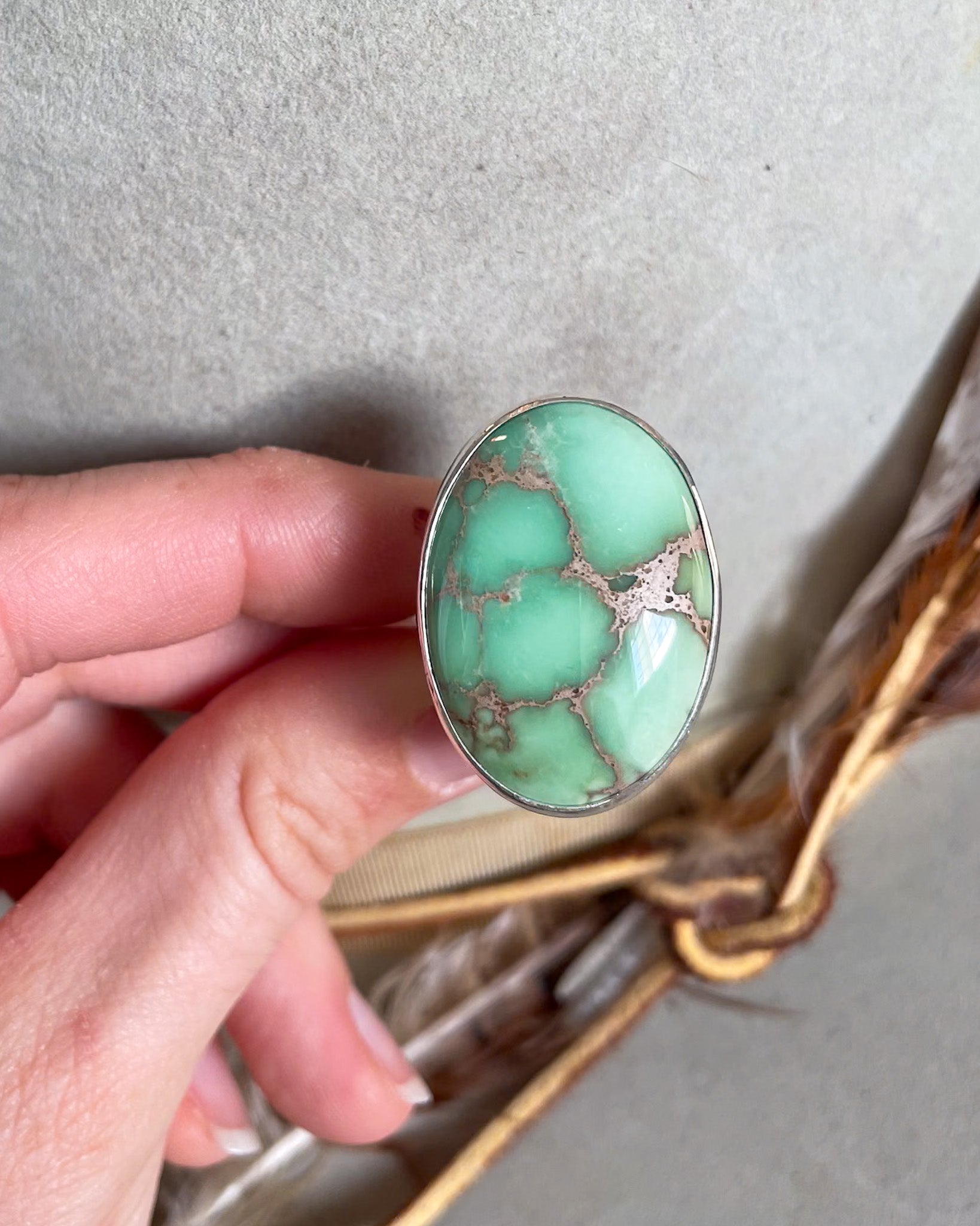 Hand holding Large oval mint green turquoise ring