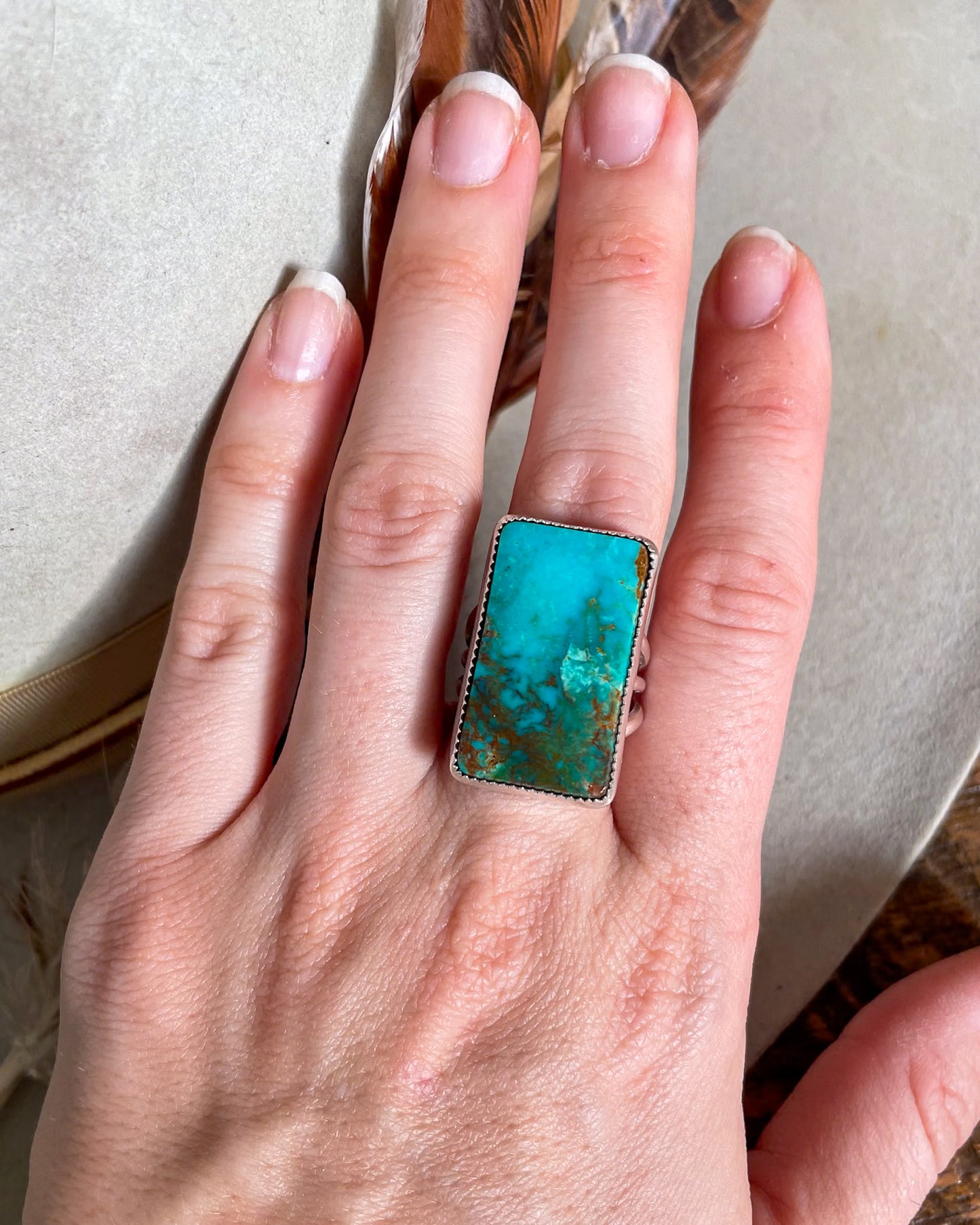 hand wearing blue and green ombre pilot mountain turquoise rectangular ring