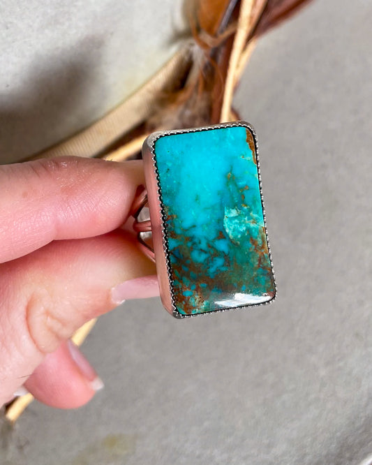 hand holding blue and green ombre pilot mountain turquoise rectangular ring