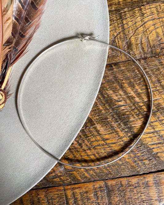 silver collar style necklace on wood background 
