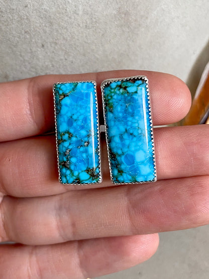 bright blue turquoise mountain bar cufflinks in serrated bezels held in hand