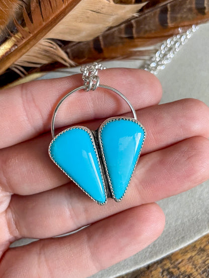 two stone sleeping beauty turquoise heart cluster pendant on chunky rolo chain held in hand