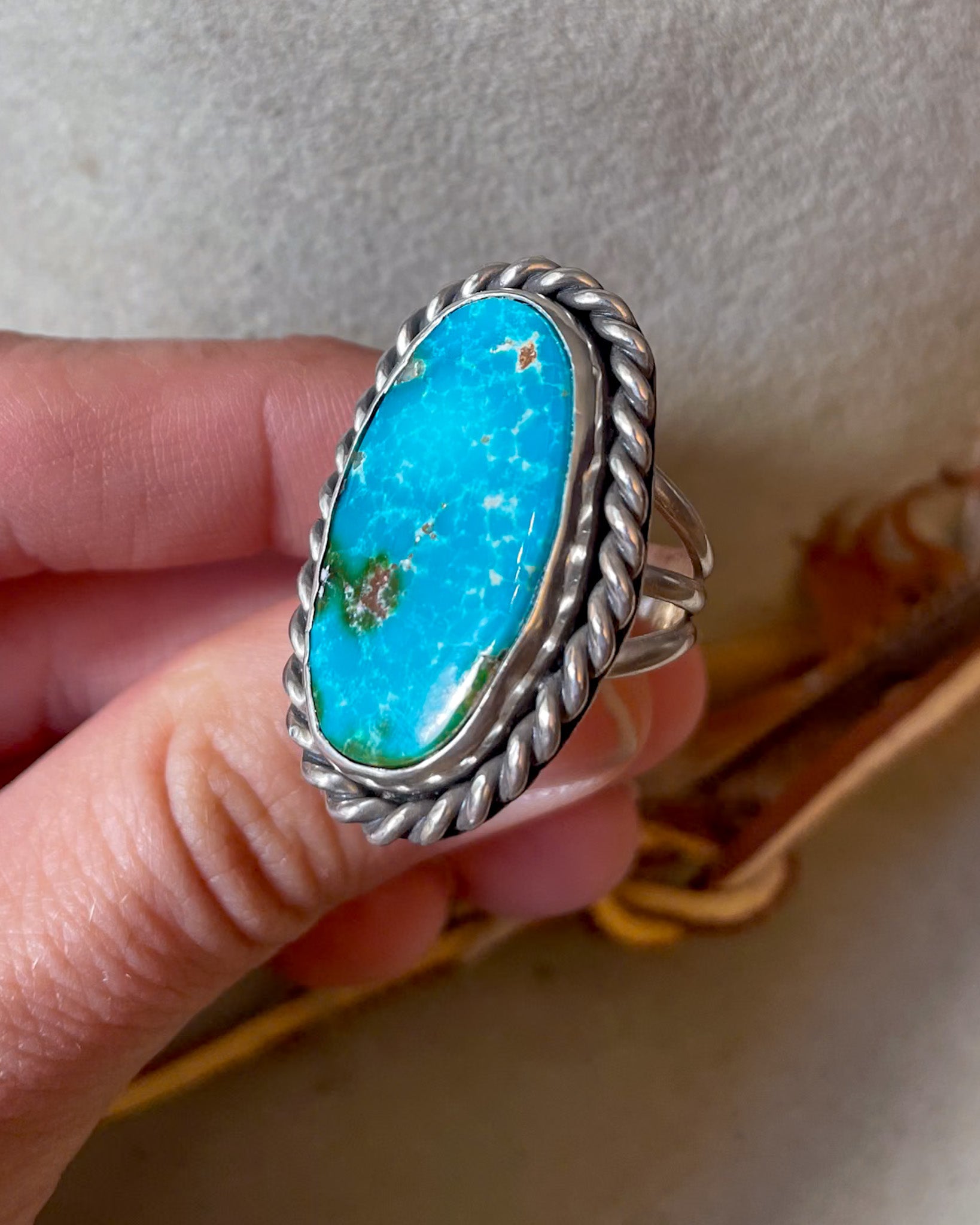 vibrant blue oval turquoise ring with thick twist border on triple split shank