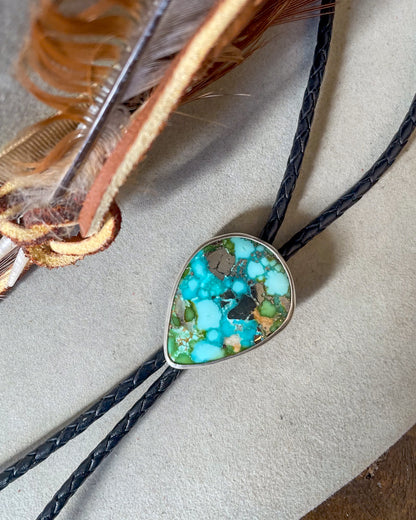 blue and green sonoran gold turquoise with natural pyrite pear cabochon bolo in smooth bezel on black braided cord