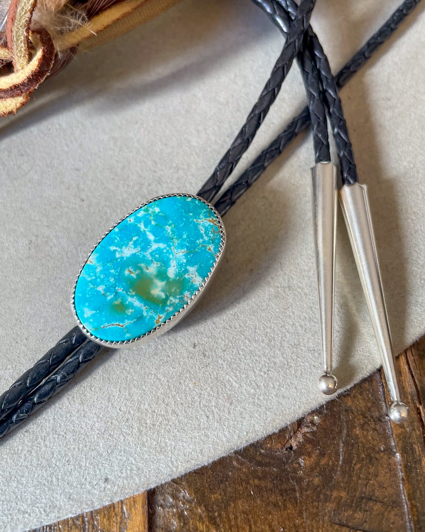 Blue with green sierra bella turquoise oval bolo on black braided leather cord with silver tips