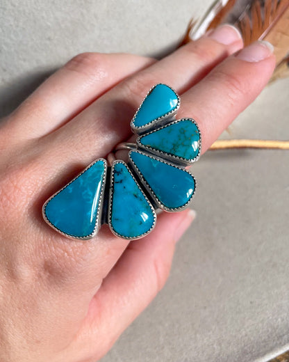 graduated peacock blue turquoise half cluster ring modeled on hand