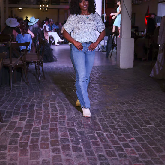 woman wearing peacock blue turquoise ring and necklace with sequin top walking on fashion show runway