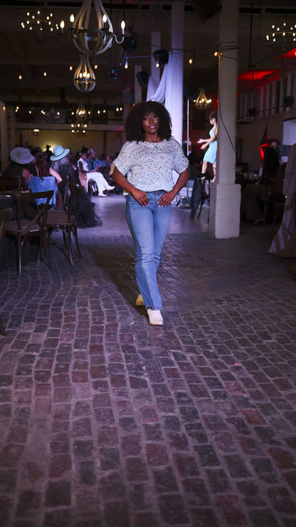 woman wearing peacock blue turquoise ring and necklace with sequin top walking on fashion show runway