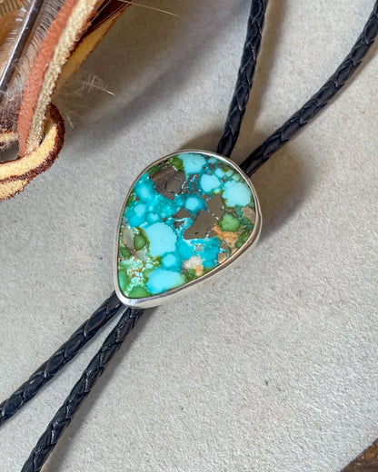 Bolo tie with a turquoise stone pendant on black leather cord