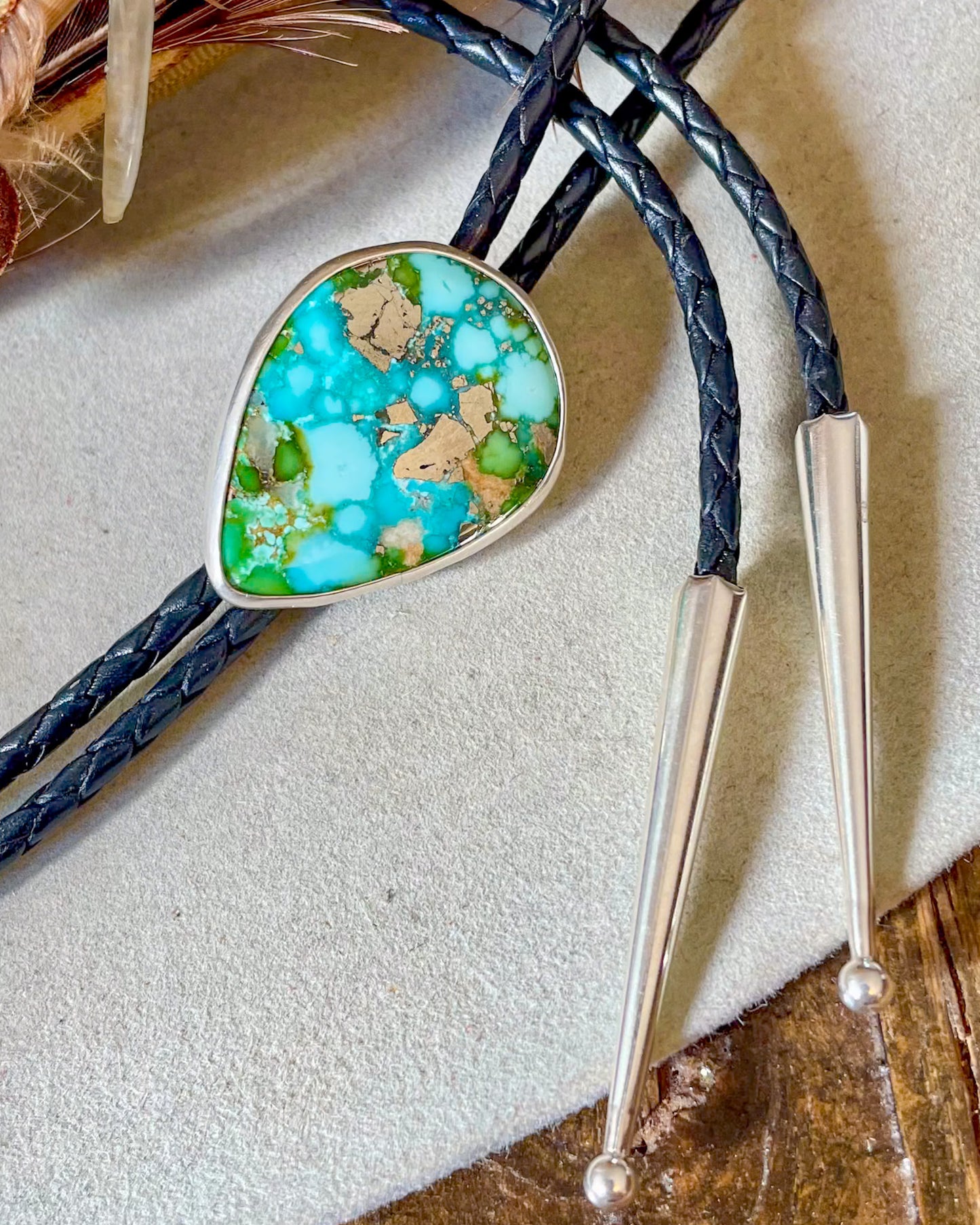 Bolo tie with turquoise and pyrite stone with black bolo cord and silver tips