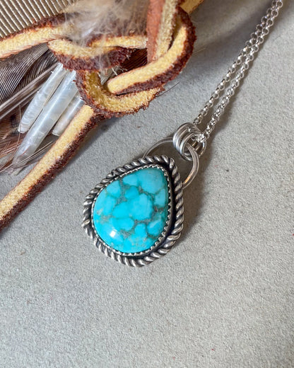 Turquoise pendant necklace on a neutral background